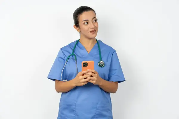 Arabski Lekarz Kobieta Noszenie Niebieski Mundur Trzyma Telefon Ręce Czyta — Zdjęcie stockowe