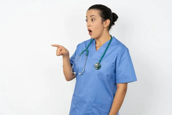 穿着制服的阿拉伯女医生 带着听诊器 在复印空间上有令人惊讶的表情 暗示了什么 — 图库照片