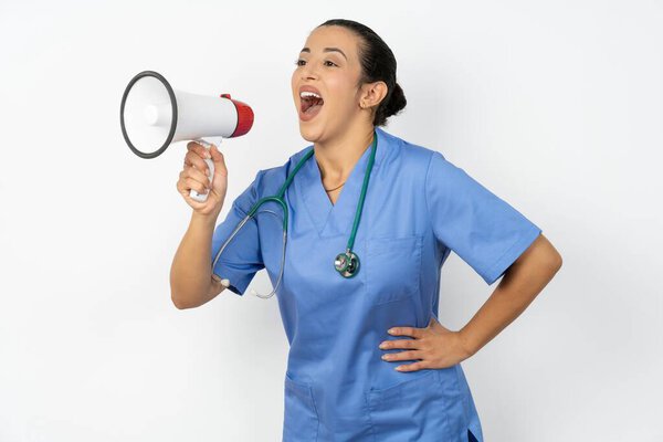Funny arab woman doctor in  uniform with stethoscope  sincere emotions lifestyle concept. Mock up copy space. Screaming in megaphone.