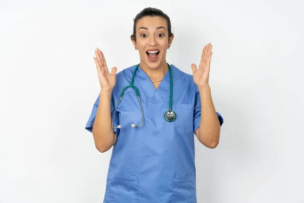 青いユニフォームを着て驚いたアラブの医師女性は 服の大きな割引を見て喜んで ショックを表現し 頭の近くに手を保ち 顎が落下しました — ストック写真
