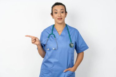 Mavi üniforma giyen olumlu Arap doktor kadın sağ üst köşede iyi bir teklif sunuyor. Bağlantı üzerine tıklamak önerilir
