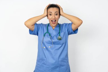 Mavi üniforma giyen neşeli Arap doktor harika haberler aldıktan sonra ellerini havaya kaldırdı..