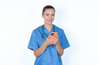 Beyaz kadın doktor cep telefonu kullanıyor, SMS mesajı yazıyor.