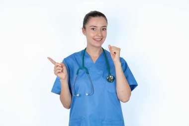 Kafkas kadın doktor üniformalı. Steteskopla boş yere bakıyor. Yumruğunu kaldır..