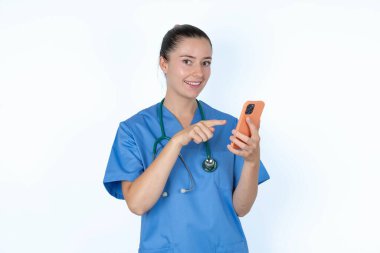 Kafkas kadın doktor üniformalı steteskop ve akıllı telefon.