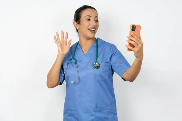 Arabiska Läkare Kvinna Bär Blå Uniform Håller Modern Mobiltelefon Och — Stockfoto