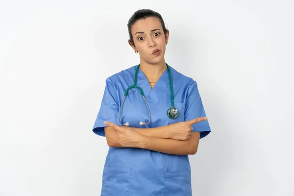 Vážná Arabská Lékařka Modré Uniformě Zkříží Ruce Ukazuje Různé Strany — Stock fotografie
