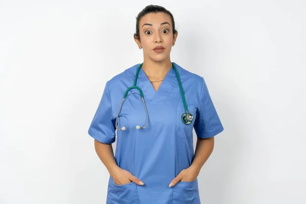身穿蓝色制服的惊慌失措的阿拉伯女医生对令人震惊的消息做出了反应 被石头砸死的模型屏住呼吸 — 图库照片