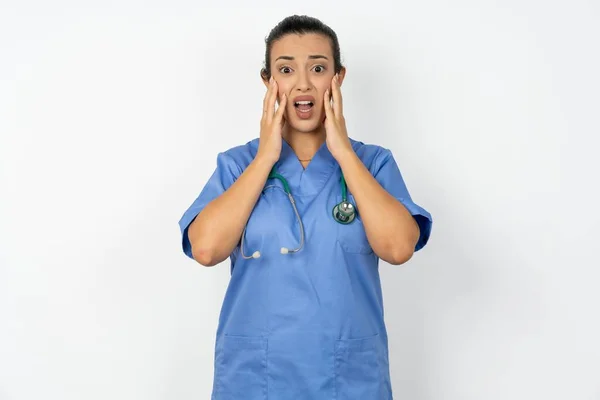 Aufgebrachte Arabische Ärztin Blauer Uniform Berührt Gesicht Mit Zwei Händen — Stockfoto