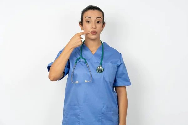 Charmig Arabiska Läkare Kvinna Bär Blå Uniform Pekar Trut Läppar — Stockfoto