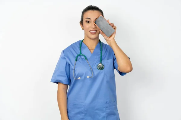 Arabski Lekarz Kobieta Noszenie Niebieski Mundur Trzymając Nowoczesny Smartfon Zakrywający — Zdjęcie stockowe