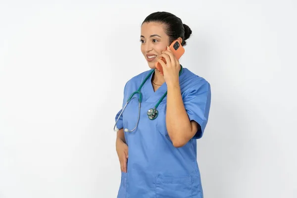 Szczęśliwy Radosny Arabski Lekarz Kobieta Noszenie Niebieski Mundur Mówić Telefon — Zdjęcie stockowe