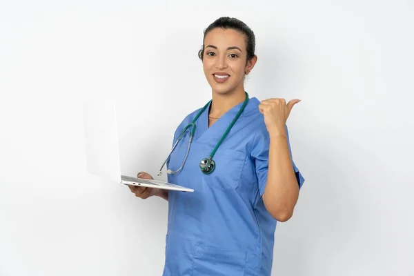 Arab Läkare Kvinna Bär Blå Uniform Med Laptop Pekar Tomt — Stockfoto