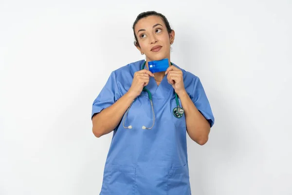 青い制服を着ているアラブの医師の女性の写真 デビットカードは空のスペースに見えます — ストック写真