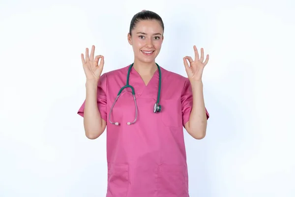 Glad Caucasian Woman Doctor Pink Uniform Shows Sign Both Hands — Stock Photo, Image