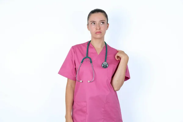 Kaukasische Vrouwelijke Arts Roze Uniform Met Stethoscoop Kijkt Pensioen Opzij — Stockfoto