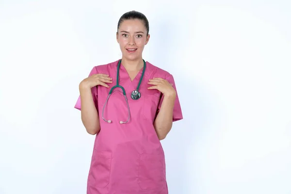 Kaukasisk Kvinna Läkare Rosa Uniform Med Stetoskop Håller Händerna Bröstet — Stockfoto
