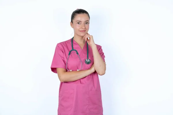 Veselá Běloška Doktorka Růžové Uniformě Stetoskopem Rukou Obličeje Dívám Radostným — Stock fotografie