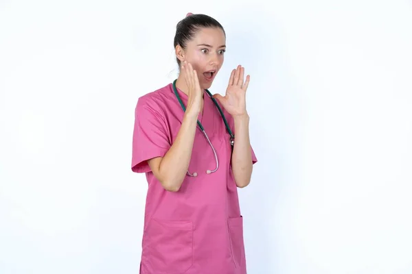 Kaukasische Vrouw Arts Roze Uniform Met Stethoscoop Met Geschokte Gezichtsuitdrukking — Stockfoto