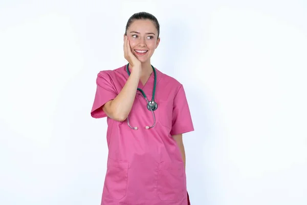Médico Mujer Caucásica Uniforme Rosa Con Estetoscopio Excitado Mirando Lado —  Fotos de Stock