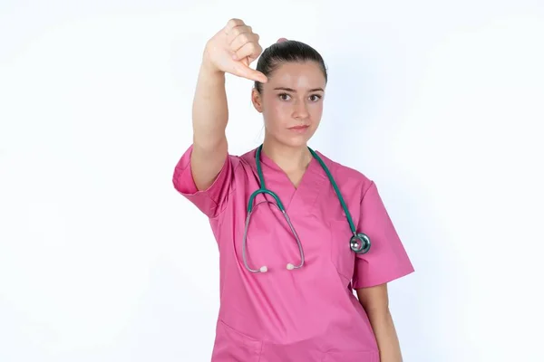 Mulher Branca Descontente Médico Uniforme Rosa Mostra Sinal Desaprovação Mantém — Fotografia de Stock