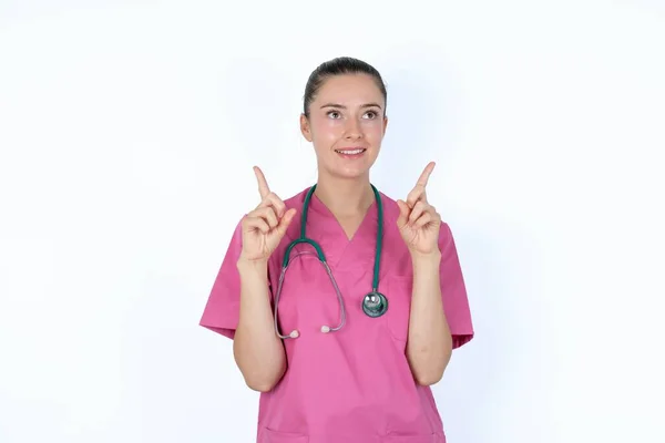 成功したフレンドリーな外観慎重な女性医師は興奮して興奮し 両方の指を指摘し 何かを示しています — ストック写真