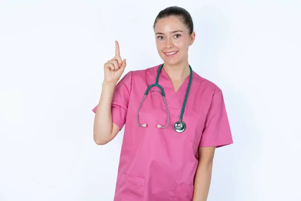 慎重な見た目白人女性の医者は巧妙な表情を持ち 1本の指を上げ 重要なことを言うことを忘れないように自分自身を覚えています — ストック写真