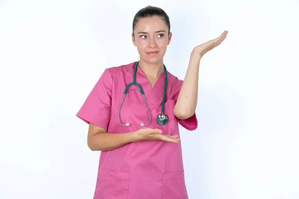 Caucasian Female Doctor Pointing Aside Both Hands Showing Something Strange — Stock Photo, Image