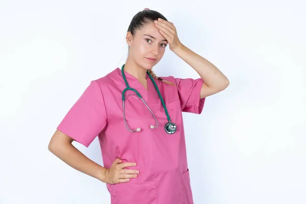 Kaukasisk Kvinnlig Läkare Rosa Uniform Med Stetoskop Vidrör Pannan Hör — Stockfoto