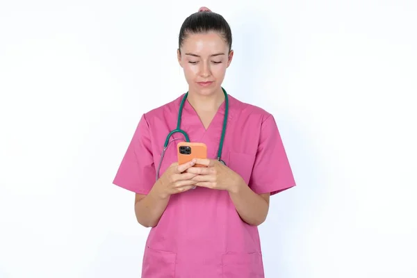 Gülümseyen Beyaz Kadın Doktor Cep Telefonu Kullanıyor Mesajlaşıyor Arkadaşlarıyla Mesajlaşıyor — Stok fotoğraf