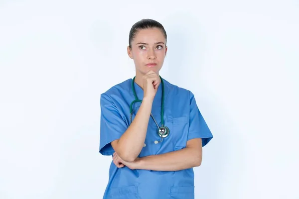 Médico Feminino Caucasiano Cuidadoso Segura Queixo Olha Para Longe Pensivamente — Fotografia de Stock