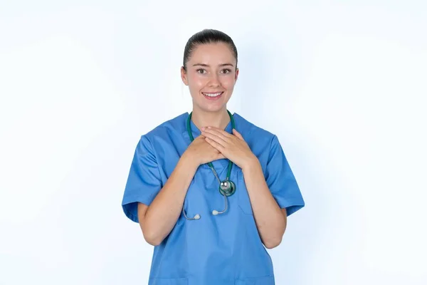Caucasian Female Doctor Expresses Happiness Laughs Pleasantly Keeps Hands Heart — Stock Photo, Image
