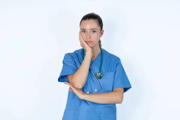 Médica Branca Triste Toca Bochecha Com Mordidas Mão Lábio Inferior — Fotografia de Stock