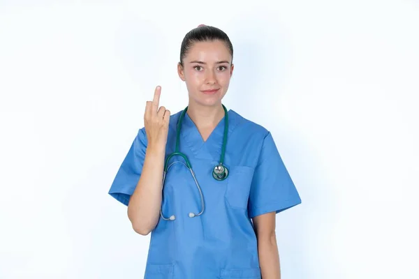 白人女性医師は中指の悪い兆候を示し 気にしないように求めます 提供と失礼な態度 — ストック写真