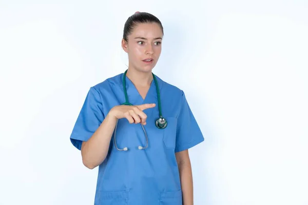 Caucasian Female Doctor Greatly Surprised Expression Points Away Copy Space — Stock Photo, Image