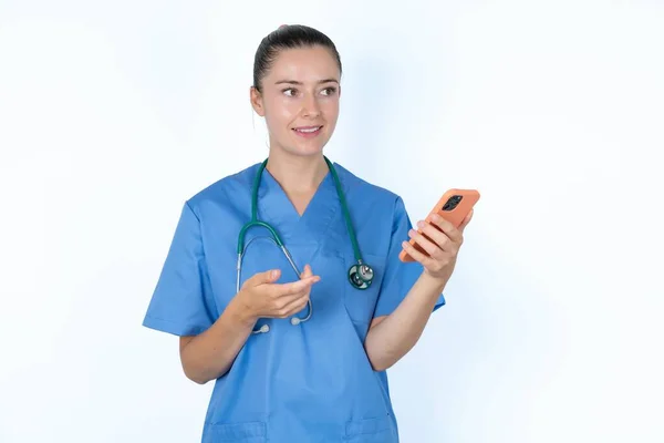 快乐的女医生举起手掌 拿着手机 用高速互联网发短信或打电话 — 图库照片