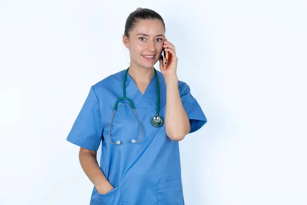 白人女性医師の女性は幸せに笑い 友人によって楽しまれている電話会話を持っています — ストック写真