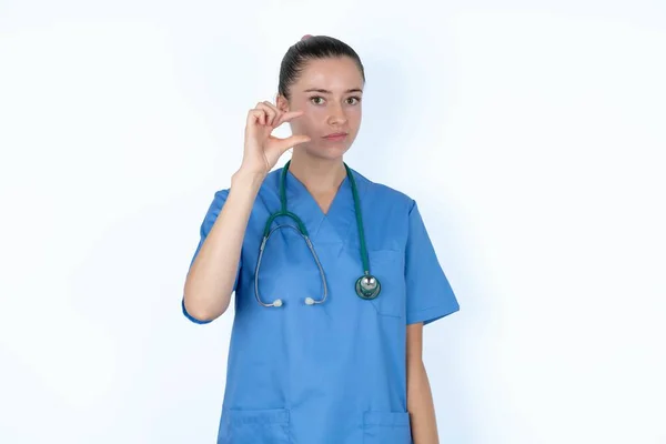 腹腔鏡で制服を着た不快な白人女性医師は 手のサインがあまり大きくないことを示しています ボディランゲージコンセプト — ストック写真
