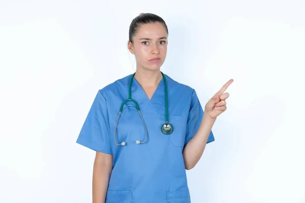 Allvarlig Kaukasisk Kvinna Läkare Uniform Med Stetoskop Leenden Ansikte Pekar — Stockfoto