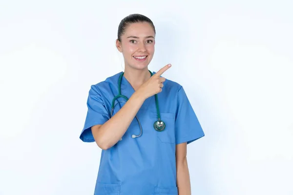 コピースペースを示す制服の白人女性医師は目新しそうに見える — ストック写真