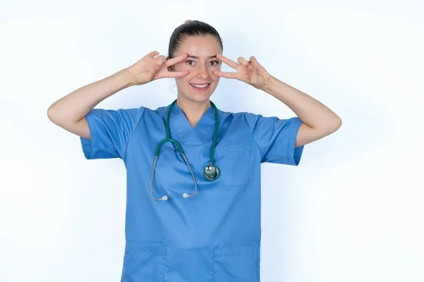 Wesoły Biały Kobieta Lekarz Mundurze Stetoskopem Pokazuje Znak Pobliżu Oczu — Zdjęcie stockowe