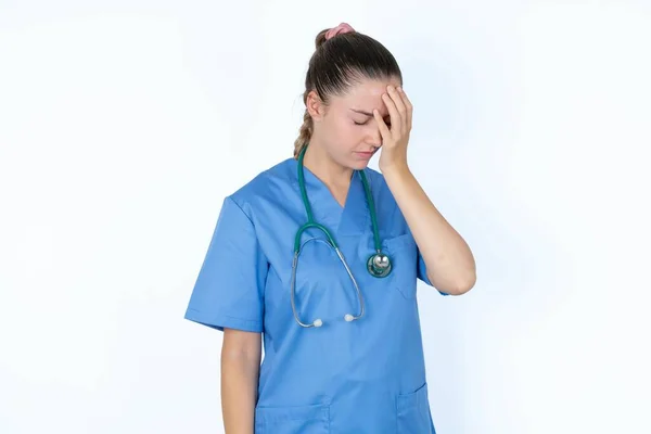 Biała Kobieta Lekarz Mundurze Stetoskopem Smutną Miną Pokrywającą Twarz Dłońmi — Zdjęcie stockowe