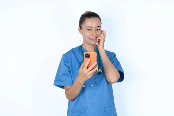 Steteskoplu Üniformalı Beyaz Kadın Doktor Elinde Telefonla Tırnak Yiyor — Stok fotoğraf