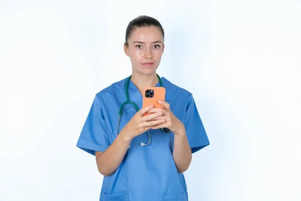 Porträtt Kaukasisk Kvinna Läkare Uniform Med Stetoskop Hålla Telefonen Två — Stockfoto