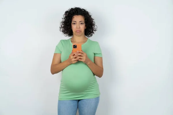烦躁不安的孕妇使用移动软件应用程序 在互联网上浏览信息 拿着现代手机 — 图库照片