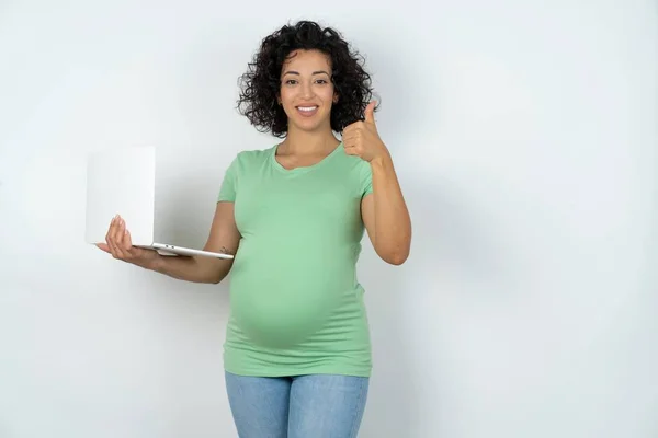 漂亮迷人的孕妇拿着上网本 竖起大拇指 — 图库照片
