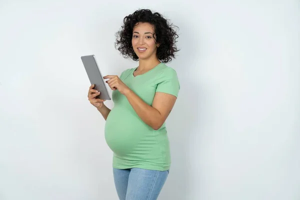 快乐孕妇手持数码平板电脑和浏览互联网的照片 — 图库照片