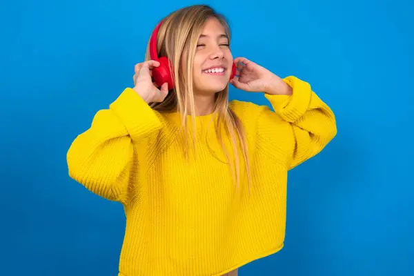 Hermosa Chica Adolescente Rubia Vistiendo Suéter Amarillo Sobre Pared Azul —  Fotos de Stock