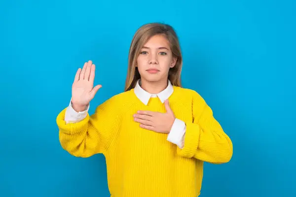 Kaukaska Nastolatka Dziewczyna Żółtym Swetrze Niebieskiej Ścianie Przysięga Ręki Klatkę — Zdjęcie stockowe