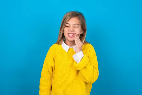 Caucasian Teen Girl Wearing Yellow Sweater Blue Wall Touching Mouth — Stock Photo, Image